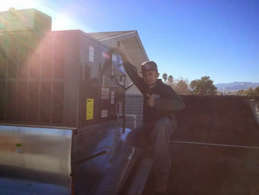HVAC technician performing AC Tune-Up on a rooftop unit in Somers